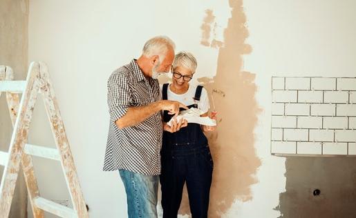 一对老夫妇正在他们的房子里画画